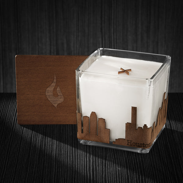 Image of a 4x4x4 soy candle featuring a mahogany scent, crackling wood wick, with a wood lid and a Houston skyline wrap design.