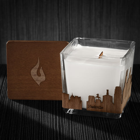 Image of a 3x3x3 soy candle featuring a mahogany scent, crackling wood wick, with a wood lid and a Nashville City skyline wrap design.