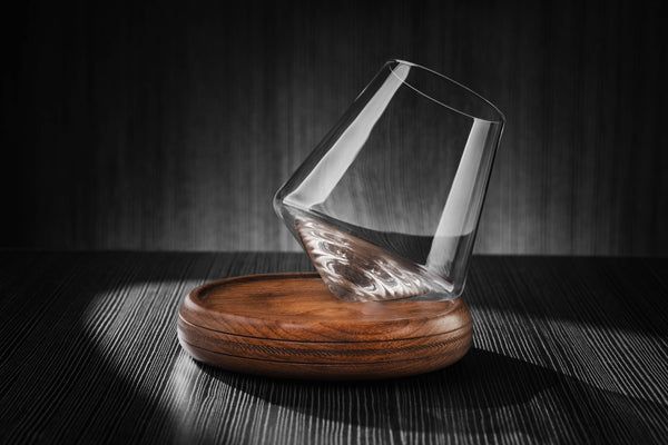 12oz revolving glass with a reversible wood coaster, standing on its side ready to revolve around the coaster. 