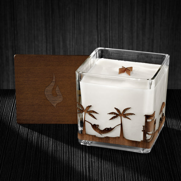 Image of a 4x4x4 soy candle featuring a mahogany scent, crackling wood wick, with a wood lid and an Beach scene wrap design.