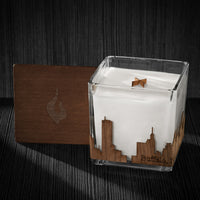 Image of a 4x4x4 soy candle featuring a mahogany scent, crackling wood wick, with a wood lid and an Buffalo, NY skyline wrap design.