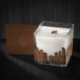 Image of a 4x4x4 soy candle featuring a mahogany scent, crackling wood wick, with a wood lid and an Charlotte skyline wrap design.