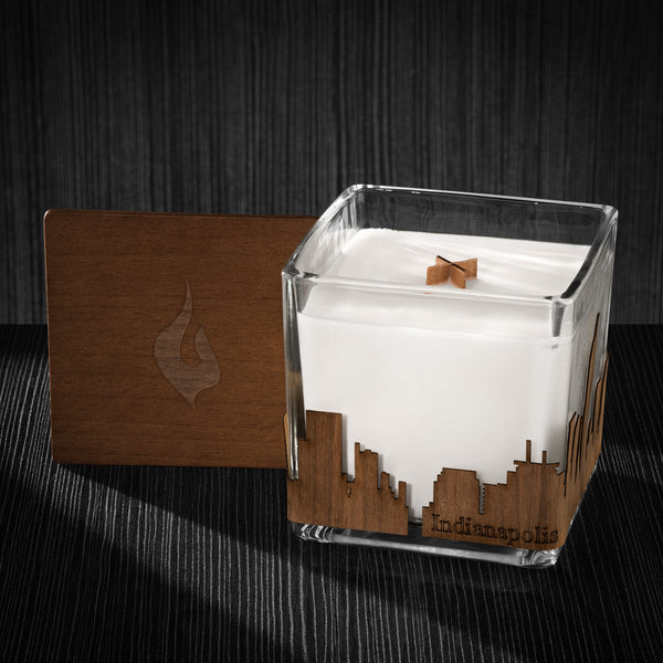 Image of a 4x4x4 soy candle featuring a mahogany scent, crackling wood wick, with a wood lid and an Indianapolis skyline wrap design.