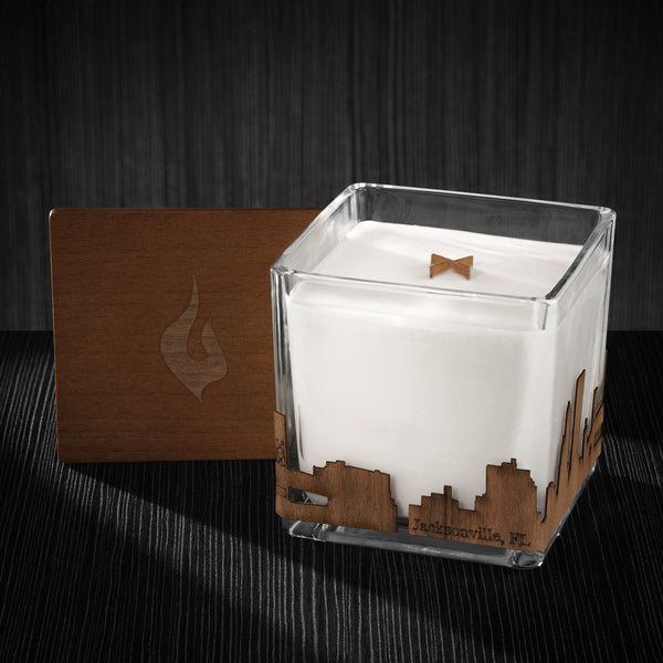 Image of a 4x4x4 soy candle featuring a mahogany scent, crackling wood wick, with a wood lid and an Jacksonville, FL skyline wrap design.