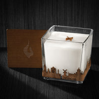 Image of a 4x4x4 soy candle featuring a mahogany scent, crackling wood wick, with a wood lid and a Jerusalem skyline wrap design.