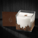 Image of a 4x4x4 soy candle featuring a mahogany scent, crackling wood wick, with a wood lid and a Miami City skyline wrap design.