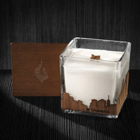 Image of a 4x4x4 soy candle featuring a mahogany scent, crackling wood wick, with a wood lid and a Minneapolis City skyline wrap design.