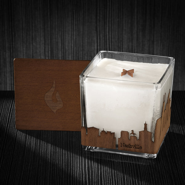 Image of a 4x4x4 soy candle featuring a mahogany scent, crackling wood wick, with a wood lid and a Nashville City skyline wrap design.