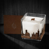 Image if a 4x4x4 soy candle featuring a mahogany scent, crackling wood wick, with a wood lid and a New Orleans skyline wrap design.