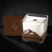 Image of a 4x4x4 soy candle featuring a mahogany scent, crackling wood wick, with a wood lid and a Pacific Northwest skyline wrap design.
