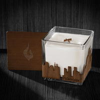 Image of a 4x4x4 soy candle featuring a mahogany scent, crackling wood wick, with a wood lid and a Philadelphia City skyline wrap design.
