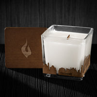 Image of a 3x3x3 soy candle featuring a mahogany scent, crackling wood wick, with a wood lid and an Cincinnati skyline wrap design.
