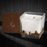 Image of a 3x3x3 soy candle featuring a mahogany scent, crackling wood wick, with a wood lid and a Jerusalem skyline wrap design.