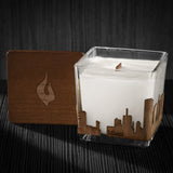Image of a 3x3x3 soy candle featuring a mahogany scent, crackling wood wick, with a wood lid and a Miami City skyline wrap design.