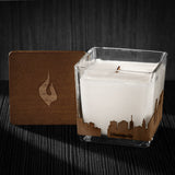 Image of a 3x3x3 soy candle featuring a mahogany scent, crackling wood wick, with a wood lid and a Minneapolis City skyline wrap design.