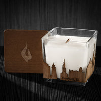 Image of a 3x3x3 soy candle featuring a mahogany scent, crackling wood wick, with a wood lid and a New Port City skyline wrap design.