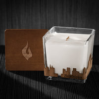 Image of a 3x3x3 soy candle featuring a mahogany scent, crackling wood wick, with a wood lid and a Philadelphia City skyline wrap design.