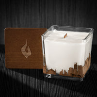 Image of a 3x3x3 soy candle featuring a mahogany scent, crackling wood wick, with a wood lid and a San Jose skyline wrap design.