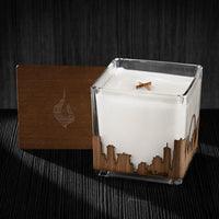 Image of a 4x4x4 soy candle featuring a mahogany scent, crackling wood wick, with a wood lid and a St. Louis skyline wrap design.
