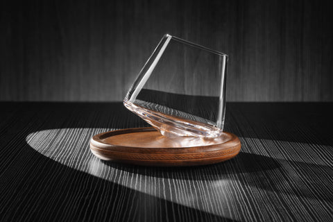 5oz revolving glass on wood coaster. The glass is on its side ready to rotate.