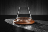 5oz revolving glass with a reversible wood coaster. The glass is set standing up in its idle position on the reversible coaster